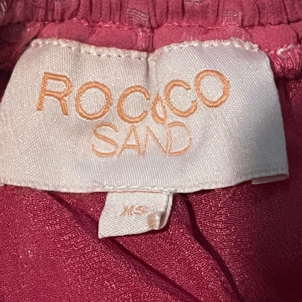 ROCOCO SAND Orlean Short Mini Skirt in Pink. Size XS. Pom Pom tassels.